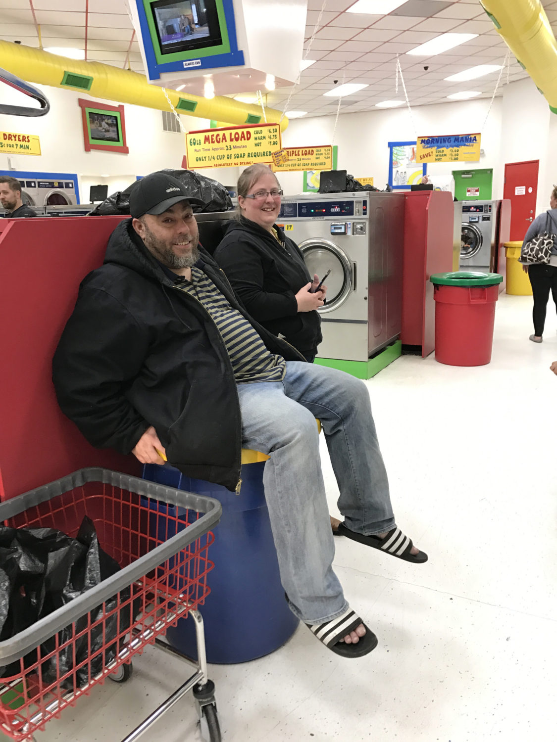 Man sitting on a garbage can at Laundry Love QC event at Laundromania